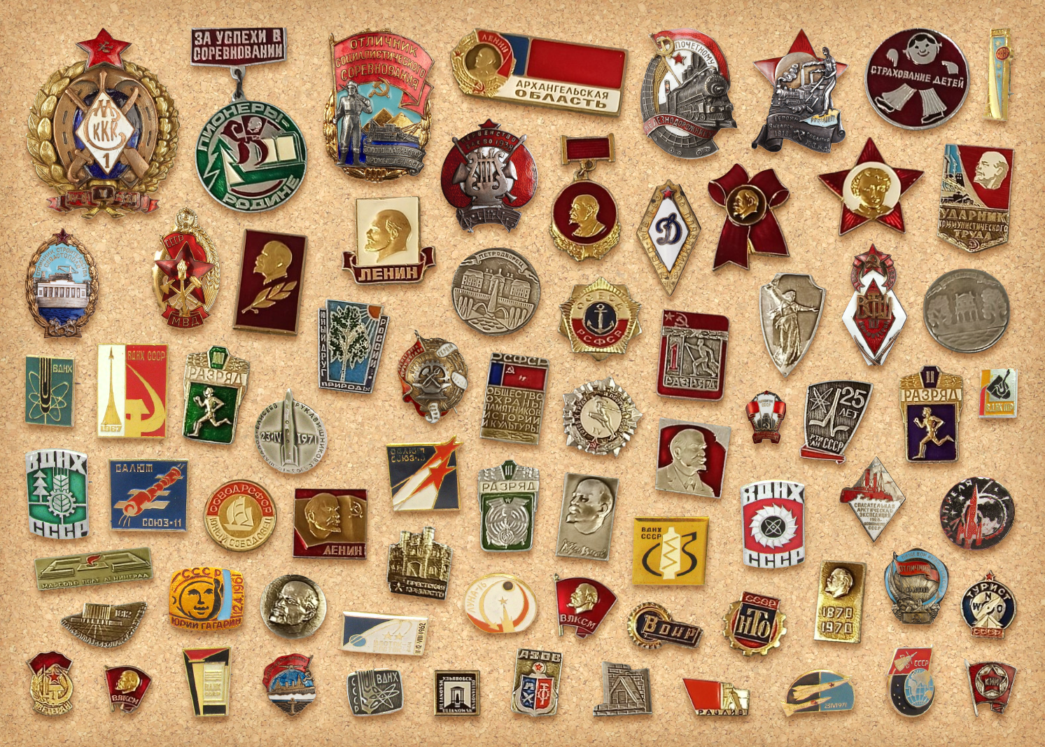 Vintage Soviet enamel and metal badges pinned to a cork board background.